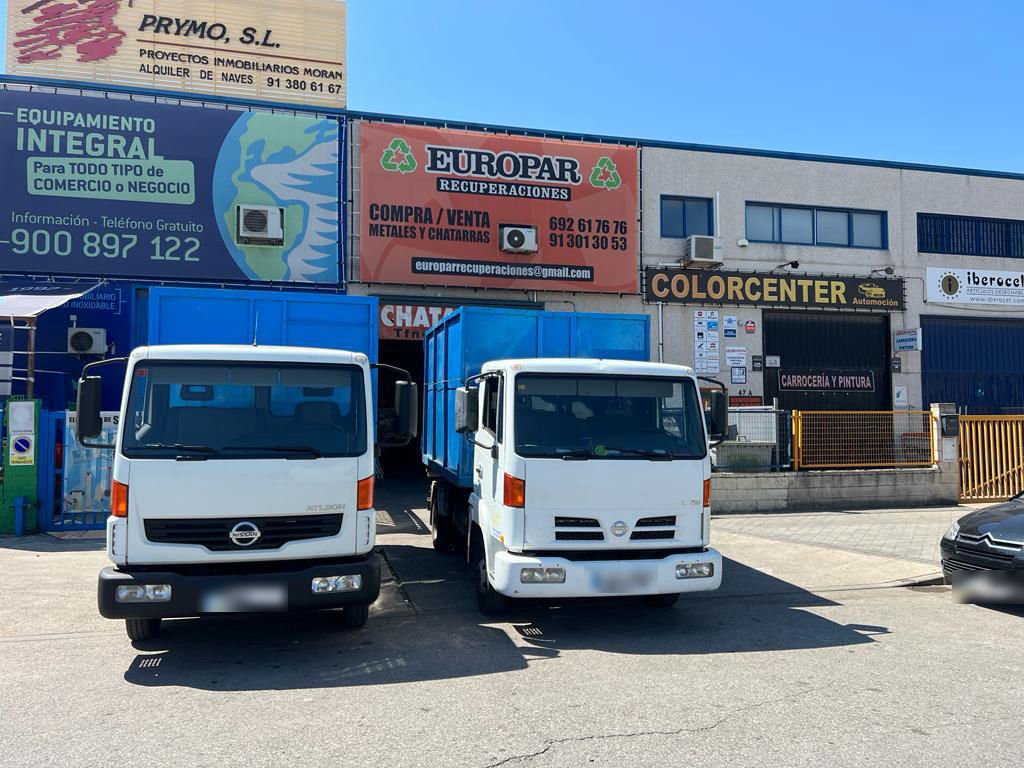 Fachada de la nave de Europar Recuperaciones, con el rótulo naranja y dos camiones delante